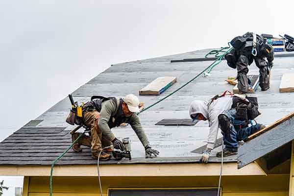 Professional roofing company Oklahoma City checking shingles and roof condition